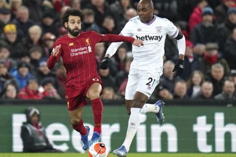 Liverpool's Mohamed Salah, left, takes the ball away from West Ham's Angelo Ogbonna during the English Premier League soccer match between Liverpool and West Ham at Anfield Stadium in Liverpool, England, Monday, Feb. 24, 2020. (AP Photo/Jon Super)