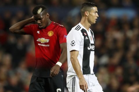Manchester United's Paul Pogba, left, and Juventus' Cristiano Ronaldo during the  Champions League soccer match at Old Trafford, Manchester, England, Tuesday Oct. 23, 2018. (Martin Rickett/PA via AP)