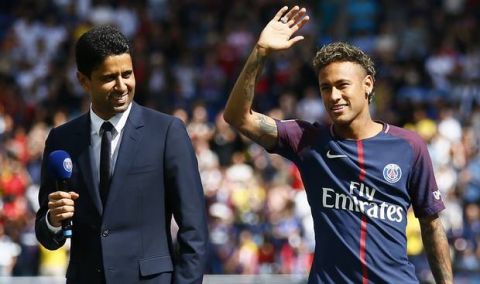 Brazilian soccer star Neymar waves to fans next to PSG president Nasser Ghanim Al-Khelaïfi at the Parc des Princes stadium in Paris, Saturday, Aug. 5, 2017, during his official presentation to fans ahead of Paris Saint-Germain's season opening match against Amiens. Neymar would not play in the club's season opener as the French football league did not receive the player's international transfer certificate before Friday's night deadline. The Brazil star became the most expensive player in soccer history after completing his blockbuster transfer from Barcelona for 222 million euros ($262 million) on Thursday. (AP Photo/Francois Mori)