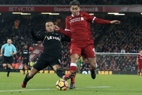 Liverpool's Roberto Firmino, right, is tackled by Swansea City's Martin Olsson during the English Premier League soccer match at Anfield, Liverpool, England, Tuesday Dec. 26, 2017. (Peter Byrne/PA via AP)