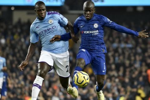 Chelsea's N'Golo Kante, right, controls the ball to shoot and score the opening goal nest to Manchester City's Benjamin Mendy, left, during the English Premier League soccer match between Manchester City and Chelsea at Etihad stadium in Manchester, England, Saturday, Nov. 23, 2019. (AP Photo/Rui Vieira)