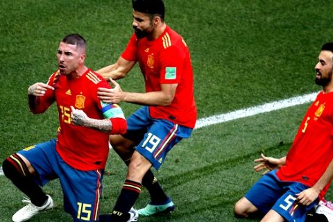 From left, Spain's Sergio Ramos, Diego Costa and Sergio Busquets celebrate the opening goal scored as an own goal by Russia's Sergei Ignashevich during the round of 16 match between Spain and Russia at the 2018 soccer World Cup at the Luzhniki Stadium in Moscow, Russia, Sunday, July 1, 2018. (AP Photo/Vincent Michel)