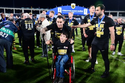 O μικρός Γιαννάκης με τον Σέρχιο Αραούχο κατά τη διάρκεια των πανηγυρισμών των παικτών της ΑΕΚ για το τρόπαιο του Κυπέλλου Ελλάδας Novibet | 24 Μαΐου 2023