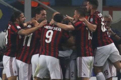 AC Milan's Suso celebrates with teammates after scoring during the Serie A soccer match between Inter Milan and AC Milan, at the Milan San Siro Stadium, Italy, Sunday, Oct. 15, 2017. (AP Photo/Antonio Calanni)