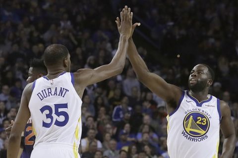 Golden State Warriors forward Kevin Durant (35) celebrates with forward Draymond Green (23) during the first half of an NBA basketball game against the Phoenix Suns in Oakland, Calif., Monday, Oct. 22, 2018. (AP Photo/Jeff Chiu)