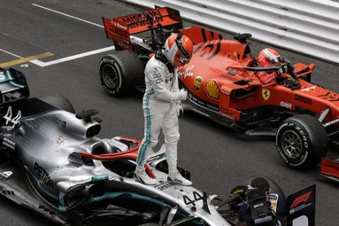 Winner Mercedes driver Lewis Hamilton of Britain, left, reacts standing on his car beside 2nd placed Ferrari driver Sebastian Vettel of Germany, right, after the Monaco Formula One Grand Prix race, at the Monaco racetrack, in Monaco, Sunday, May 26, 2019. (AP Photo/Luca Bruno)