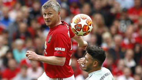 Manchester United Legends' Ole Gunnar Solskjaer, left, vies for the ball with Bayern Munich Legends' Martin Demichelis  during the legends soccer match at Old Trafford, in Manchester, Sunday May 26, 2019. (Martin Rickett/PA via AP)