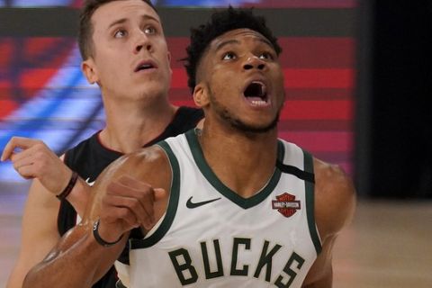 Miami Heat's Duncan Robinson, rear, and Milwaukee Bucks' Giannis Antetokounmpo, front, compete for a rebound during the first half of an NBA basketball conference semifinal playoff game, Monday, Aug. 31, 2020, in Lake Buena Vista, Fla. (AP Photo/Mark J. Terrill)