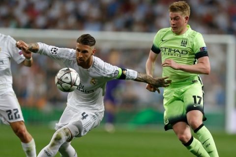 Real Madrid's Sergio Ramos, center, controls the ball in from of Manchester City's Kevin De Bruyne, right, during the Champions League semifinal second leg soccer match between Real Madrid and Manchester City at the Santiago Bernabeu stadium in Madrid, Wednesday May 4, 2016. (AP Photo/Francisco Seco)