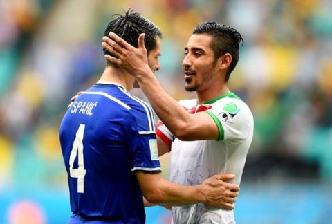 SALVADOR, BRAZIL - JUNE 25:  Emir Spahic of Bosnia and Herzegovina and Reza Ghoochannejhad of Iran greet each other after the 2014 FIFA World Cup Brazil Group F match between Bosnia and Herzegovina and Iran at Arena Fonte Nova on June 25, 2014 in Salvador, Brazil.  (Photo by Jamie McDonald/Getty Images)