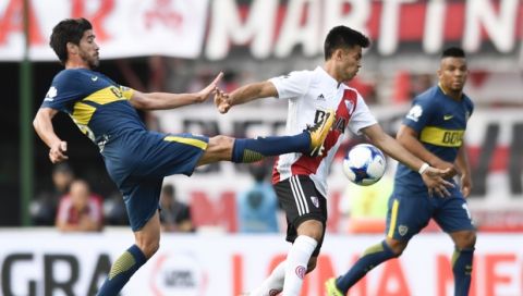 Boca Juniors' Pablo Perez, left, fights for the ball with River Plate's Gonzalo Martinez, center, during local tournament soccer match in Buenos Aires, Argentina, Sunday, November 5, 2017. (AP Photo/Gustavo Garello)