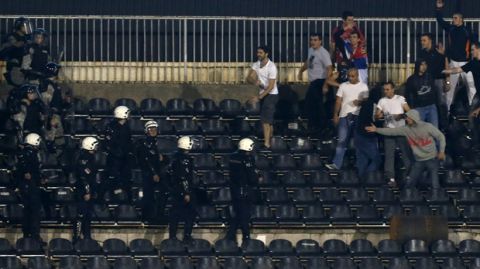 Serbian riot police officers clash with soccer fans during the Euro 2016 Group I qualifying match between Serbia and Albania, at the Partizan stadium in Belgrade, Serbia, Tuesday, Oct. 14, 2014. The match was suspended. (AP Photo/Darko Vojinovic)
