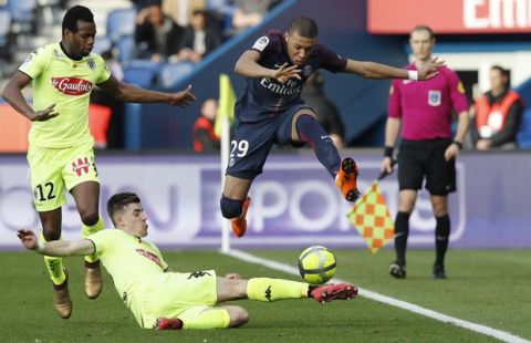 PSG's Kylian Mbappe jumps over Angers' Baptiste Santamaria as Angers' Lassana Coulibaly looks on during the French League One soccer match between Paris Saint-Germain and Angers at the Parc des Princes Stadium, in Paris, France, Wednesday, March 14, 2018. (AP Photo/Christophe Ena)