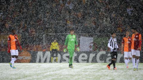 Galatasaray's and Juventus' players leave the pitch after a heavy snow fall halted their UEFA Champions League group B football match at the TT Arena Stadium in Istanbul on December 30, 2013. AFP PHOTO/BULENT KILIC        (Photo credit should read BULENT KILIC/AFP/Getty Images)