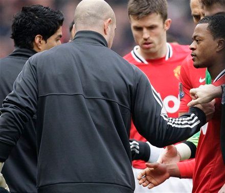 Manchester United's Patrice Evra, right, attempts to shake hands with Liverpool's Luis Suarez, left, during their English Premier League soccer match at Old Trafford Stadium, Manchester, England, Saturday, Feb. 11, 2012.  Suarez refused to shake the hand of the Manchester United defender Evra, their first meeting since the Liverpool forward was banned for eight matches for racially abusing Evra in October 2011.(AP Photo/Jon Super)