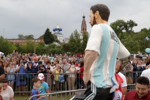 People gather around a sculpture cake to mark Lionel Messi's birthday near Argentina training camp base at the 2018 World Cup in Bronnitsy, Russia, Sunday, June 24, 2018. Wth a cake sculpture and a music festival the town of Bronnitsy celebrated the striker's 31st birthday.(AP Photo/Ricardo Mazalan)