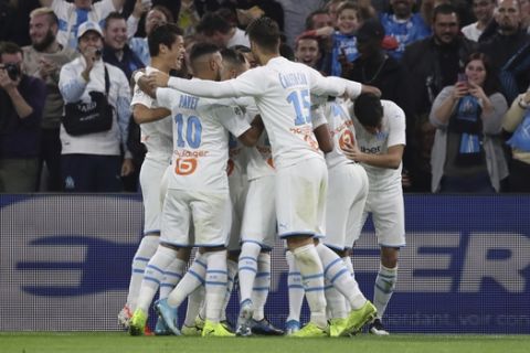 Marseille players celebrate after Marseille's Morgan Sanson scored his side's opening goal during the French League One soccer match between Marseille and Lille at the Velodrome stadium in Marseille, southern France, Saturday, Nov. 2, 2019. (AP Photo/Daniel Cole)