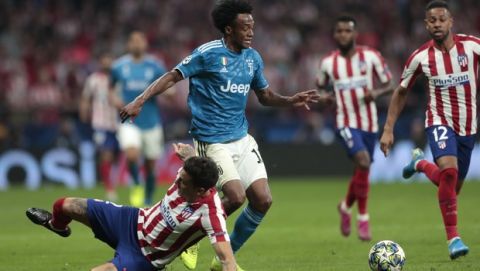 Juventus' Juan Cuadrado, center, vies for the ball with Atletico Madrid's Jose Gimenez, left, and Atletico Madrid's Renan Lodi, right, during the Champions League Group D soccer match between Atletico Madrid and Juventus at the Wanda Metropolitano stadium in Madrid, Spain, Wednesday, Sept. 18, 2019. (AP Photo/Bernat Armangue)