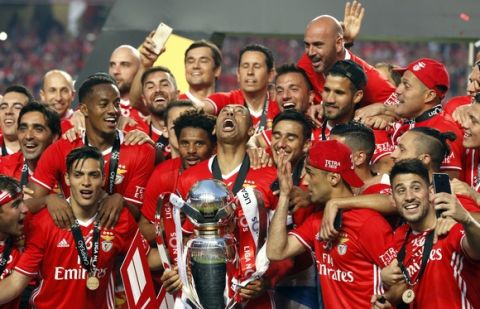Benfica's team captain Luisao lifts the Portuguese league trophy at the end of the soccer match between Benfica and Vitoria de Guimaraes at the Luz stadium in Lisbon, Saturday, May 13, 2017. Benfica won the match 5-0 to clinch the championship title with one round left to play. (AP Photo/Pedro Rocha)