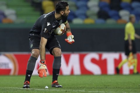 Sporting goalkeeper Rui Patricio picks up balls, looking like golf balls, thrown on the pitch during the Europa League round of 16 first leg soccer match between Sporting CP and FC Viktoria Plzen at the Alvalade stadium in Lisbon, Thursday March 8, 2018. (AP Photo/Armando Franca)