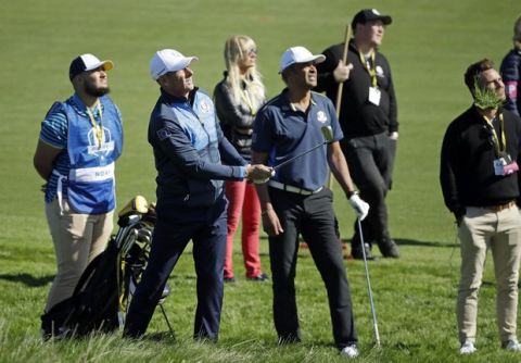 French tennis legends Yanick Noah watches as Guy Forget, left, plays from the rough on the 1st fairway during the Ryder Cup Celebrity Challenge match at Le Golf National in Saint-Quentin-en-Yvelines, outside Paris, France, Tuesday, Sept. 25, 2018. The 42nd Ryder Cup will be held in France from Sept. 28-30, 2018 at Le Golf National. (AP Photo/Matt Dunham)