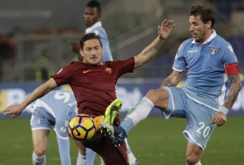 Roma's Francesco Totti, left, and Lazio's Lucas Biglia vie for the ball during an Italian Cup, first-leg, semifinal soccer match at the Rome Olympic stadium, Wednesday, March 1, 2017. (AP Photo/Gregorio Borgia)