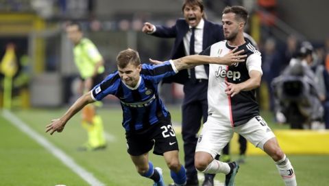 Inter Milan's Nicolo Barella, left, fights for the ball with Juventus' Miralem Pjanic during a Serie A soccer match between Inter Milan and Juventus, at the San Siro stadium in Milan, Italy, Sunday, Oct. 6, 2019. (AP Photo/Luca Bruno)