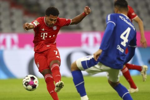 Bayern's Serge Gnabry, left, shoots to score his team's opening goal, as Schalke's Ozan Kabak, right, tries to stop him, during the German Bundesliga soccer match between FC Bayern Munich and Schalke 04 in Munich, Germany, Friday, Sept. 18, 2020. (AP Photo/Matthias Schrader)