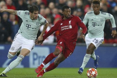 Liverpool's Georginio Wijnaldum, center, competes for the ball with Bayern midfielder Javi Martinez, left, and Bayern forward Kingsley Coman during the Champions League round of 16 first leg soccer match between Liverpool and Bayern Munich at Anfield stadium in Liverpool, England, Tuesday, Feb. 19, 2019. (AP Photo/Dave Thompson)
