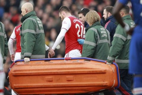 Arsenal's Calum Chambers leaves the pitch after being injured during the English Premier League soccer match between Arsenal and Chelsea, at the Emirates Stadium in London, Sunday, Dec. 29, 2019. (AP Photo/Ian Walton)