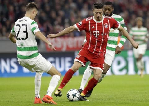 Bayern's Robert Lewandowski, right, and Celtic's Mikael Lustig challenge for the ball during a Group B Champions League soccer match between Bayern Munich and Celtic F.C. at the Allianz Arena in Munich, Germany, Wednesday, Oct. 18, 2017. (AP Photo/Matthias Schrader)