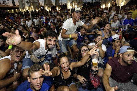 French soccer fans celebrate on the final whistle as they watch a live broadcast of the semifinal match between France and Belgium at the 2018 soccer World Cup, in Marseille, southern France, Tuesday July 10, 2018. France has advanced to the World Cup final for the first time since 2006 with a 1-0 win over Belgium. (AP Photo/Claude Paris)