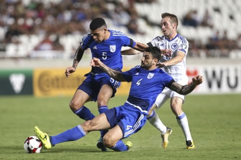 Cyprus' Giorgos Merkis, center, and Fanos Katelaris, rear left, challenge for the ball with Bosnia's Edin Visca, rear right, during their World Cup Group H qualifying soccer match between Cyprus and Bosnia-Herzegovina, at GSP stadium, in Nicosia, Cyprus, Thursday, Aug. 31, 2017. Cyprus won the game 3-2. (AP Photo/Petros Karadjias)
