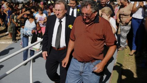 Cardiff City manager Neil Warnock, left, comforts Emiliano Sala's father, Horacio Sala at the cemetery in Santa Fe, Argentina, Saturday, Feb. 16, 2019. The Argentina-born forward died in an airplane crash in the English Channel last month when flying from Nantes in France to start his new career with English Premier League club Cardiff. (AP Photo/Natacha Pisarenko)