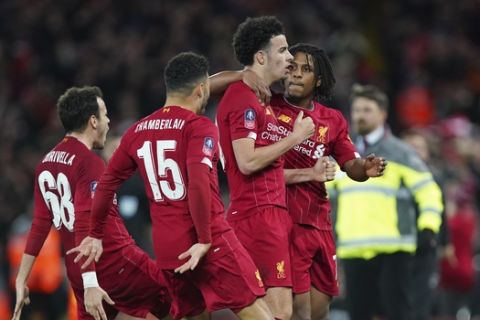 Liverpool's Curtis Jones, second from right, celebrates with his teammates after scoring his side's opening goal during the English FA Cup third round soccer match between Liverpool and Everton at Anfield stadium in Liverpool, England, Sunday, Jan. 5, 2020. (AP Photo/Jon Super)