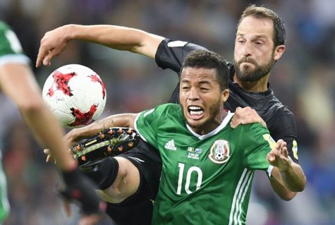 Mexico's Giovani Dos Santos is challenged by New Zealand's Andrew Durante during the Confederations Cup, Group A soccer match between Mexico and New Zealand, at the Fisht Stadium in Sochi, Russia, Wednesday, June 21, 2017. (AP Photo/Martin Meissner)