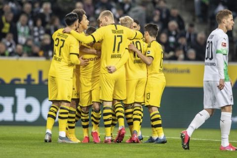 Dortmund players celebrate scoring during the Bundesliga soccer match between Borussia Monchengladbach and Borussia Dortmund, at Borussia Park, Monchengladbach, Germany, Saturday March 7, 2020. (Bernd Thissen/dpa via AP)