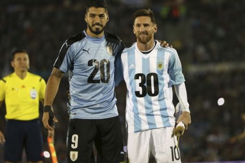 Argentina's Lionel Messi and Uruguay's Luis Suarez pose for pictures wearing the number 20 and 30 as the support the candidacy of Uruguay and Argentina for the 2030 World Cup before a 2018 World Cup qualifying soccer match in Montevideo, Uruguay, Thursday, Aug. 31, 2017.(AP Photo/Natacha Pisarenko)