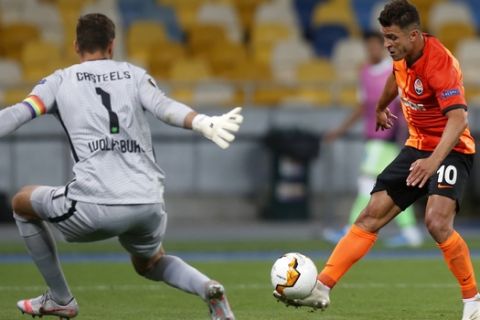 Wolfsburg's goalkeeper Koen Casteels, left, makes a save in front of Shakhtar's Junior Moraes during the Europa League round of 16 second leg soccer match between FC Shakhtar Donetsk and VfL Wolfsburg at the Olimpiyskiy Stadium in Kyiv, Ukraine, Wednesday, Aug. 5, 2020. (AP Photo/Efrem Lukatsky)