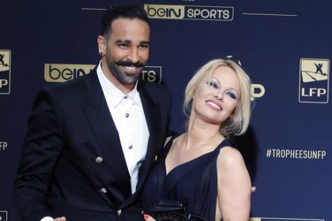 Soccer player Adil Rami and US actress Pamela Anderson pose as they arrive at the UNFP (Union of French Professional Footballers) ceremony, in Paris, France, Sunday, May 19, 2019. (AP Photo/Francois Mori)