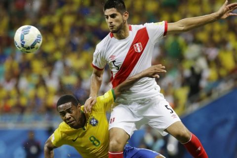 Brazil's Elias, left, fights for the ball with Peru's Carlos Zambrano during a 2018 World Cup qualifying soccer match in Salvador, Brazil, Tuesday, Nov. 17, 2015. (AP Photo/Nelson Antoine)