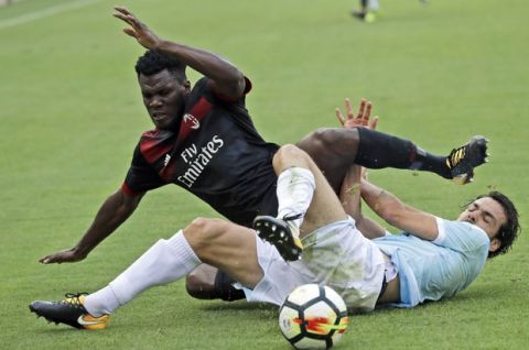 AC Milan's Franck Kessie, left, is challenged by Lazio's Marco Parolo during a Serie A soccer match between Lazio and AC Milan, at the Rome Olympic stadium, Sunday, Sept. 10, 2017. (AP Photo/Alessandra Tarantino)