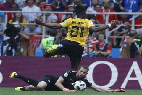 Belgium's Michy Batshuayi, top, moves the ball past Tunisia goalkeeper Farouk Ben Mustapha during the group G match between Belgium and Tunisia at the 2018 soccer World Cup in the Spartak Stadium in Moscow, Russia, Saturday, June 23, 2018. (AP Photo/Hassan Ammar)