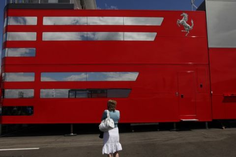 A woman stands by the Ferrari team trucks ahead of the British Formula One Grand Prix at the Silverstone racetrack, in Silverstone, England, Friday, June 19 2009. Ferrari, McLaren, Brawn GP and five other teams have announced plans for a rival series to Formula One in 2010 after the collapse of heated negotiations with F1 organizers over a budget cap for next season. Negotiations between FOTA and the FIA, the sport's governing body, had stalled over plans for a voluntary 60 million US dollars budget cap for all teams next season. (AP Photo/Lefteris Pitarakis)