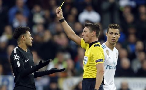 PSG's Neymar, left, reacts after getting a yellow card from referee Gianluca Rocchi of Italy while Real Madrid's Cristiano Ronaldo looks on during a Champions League Round of 16 first leg soccer match between Real Madrid and Paris Saint Germain at the Santiago Bernabeu stadium in Madrid, Spain, Wednesday, Feb. 14, 2018. (AP Photo/Francisco Seco)