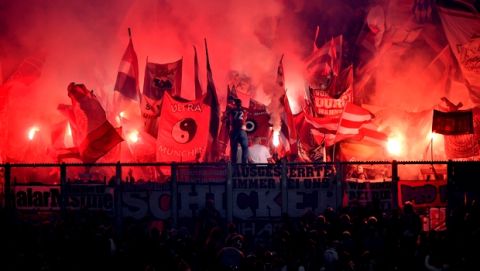 Bayern supporters burn firework during the German Bundesliga soccer match between FC Schalke 04 and Bayern Munich in Gelsenkirchen, Germany, Saturday, Sept. 22, 2018. (AP Photo/Martin Meissner)