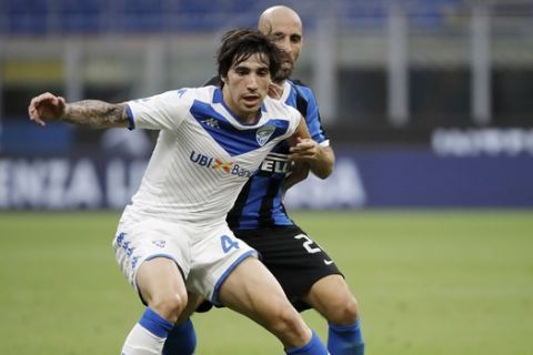 Brescia's Sandro Tonali, left, challenges for the ball with Inter Milan's Borja Valero during the Serie A soccer match between Inter Milan and Brescia at the San Siro Stadium, in Milan, Italy, Wednesday, July 1, 2020. (AP Photo/Luca Bruno)