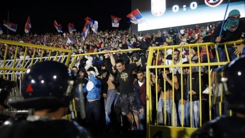 Serbian riot police try to contain Serbian supporters after a fight on the pitch broke out during the Euro 2016 Group I qualifying match between Serbia and Albania, at the Partizan stadium in Belgrade, Serbia, Tuesday, Oct. 14, 2014. (AP Photo/Marko Drobnjakovic)