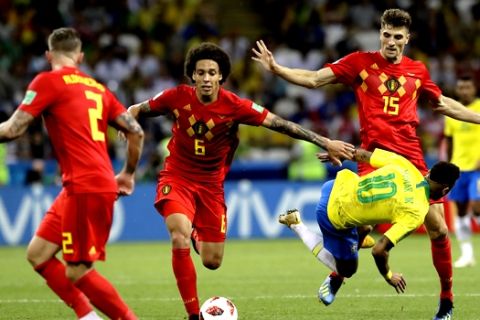 Brazil's Neymar takes a fall while battling Belgium's Axel Witsel, center, and Thomas Meunier, right, during the quarterfinal match between Brazil and Belgium at the 2018 soccer World Cup in the Kazan Arena, in Kazan, Russia, Friday, July 6, 2018. (AP Photo/Andre Penner)