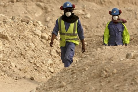FILE - In this file photo taken Monday, May 4, 2015, during a government organized media tour, workers walk back to the Al-Wakra Stadium worksite being built for the 2022 World Cup, in Doha, Qatar.  FIFA has defeated a legal challenge by trade union groups on Friday Jan 6, 2017, at a Zurich Commercial Court over picking Qatar as 2022 World Cup host and failing to ensure reforms to labor laws. (AP Photo/Maya Alleruzzo, File)